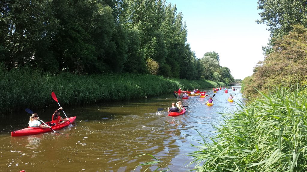 Groep kanovaarders in een en twee persoons kanoes bij Kanoverhuur Den Helder